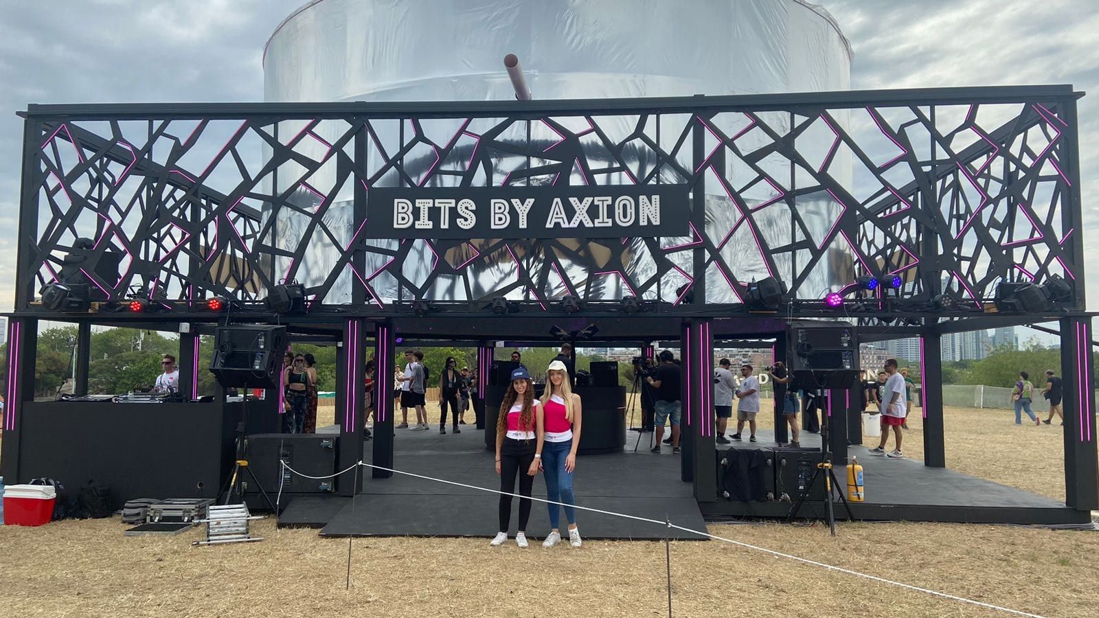 Stand Bits by Axion con estructura negra calada y público en la entrada