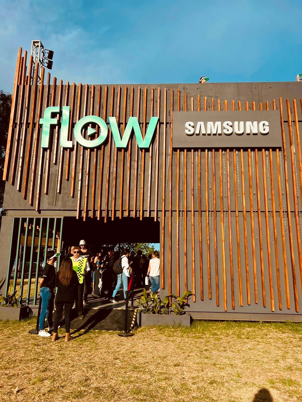 Entrada del stand de Flow y Samsung con público de noche