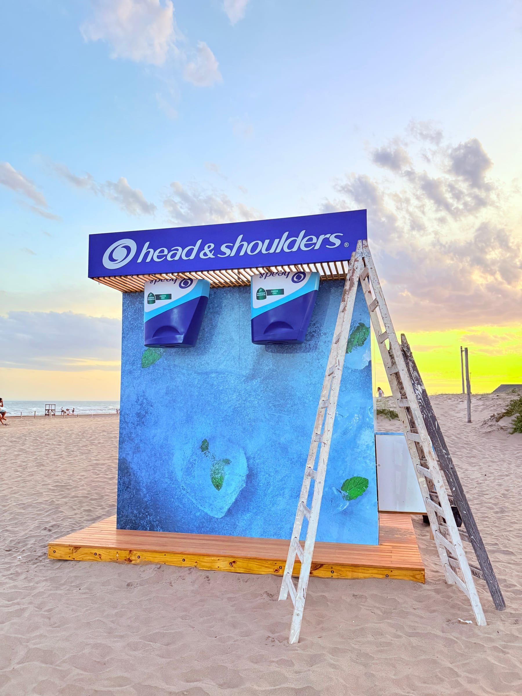Módulo de Head & Shoulders al atardecer, con promotora en la escalera