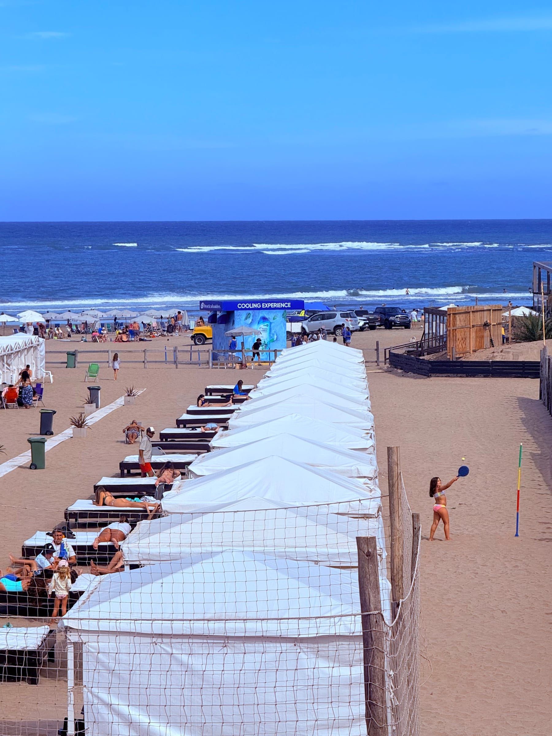Carpas blancas del Balneario Cabolargo alineadas frente al mar