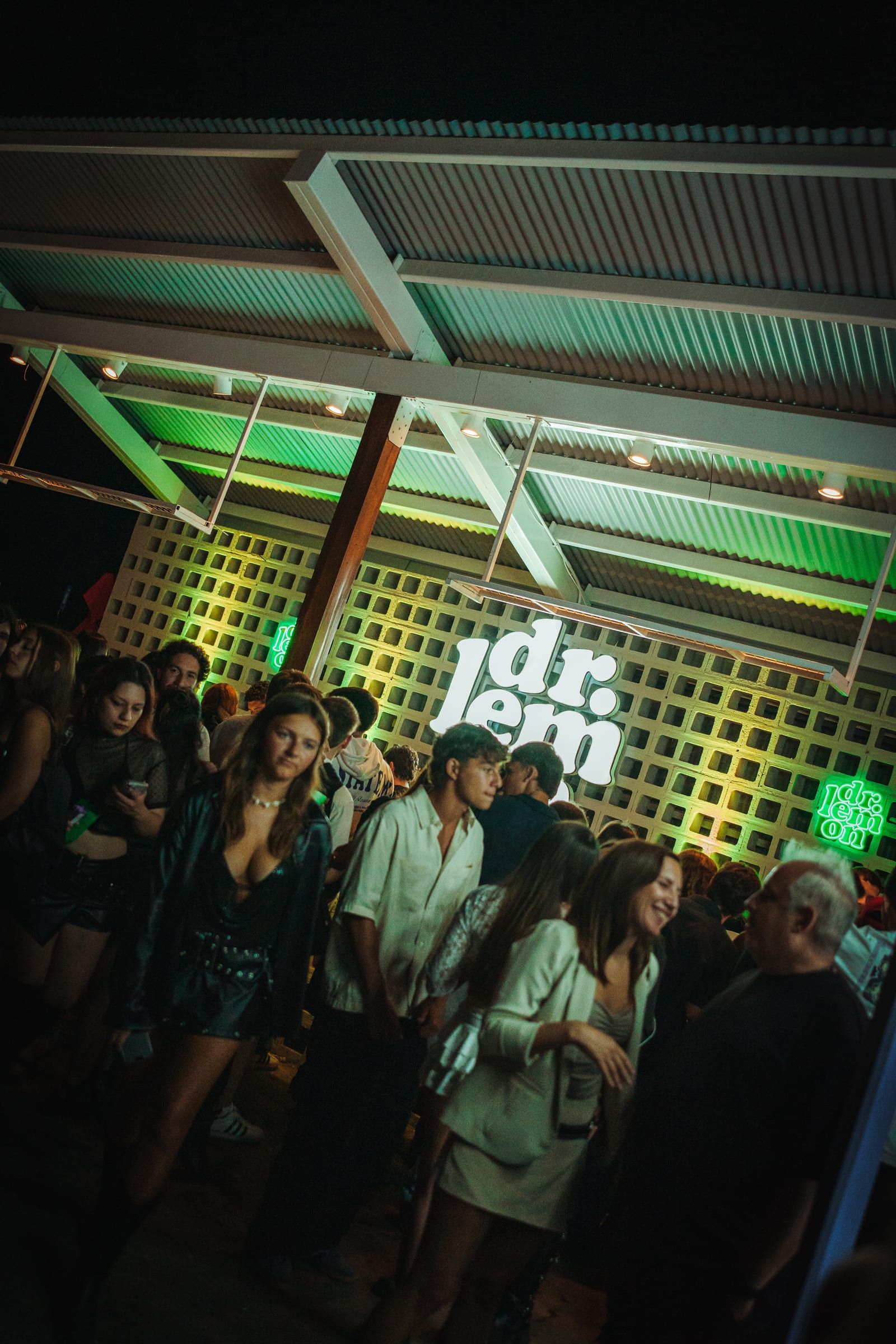 Bar con cartel de neón de Dr. Lemon y público bailando