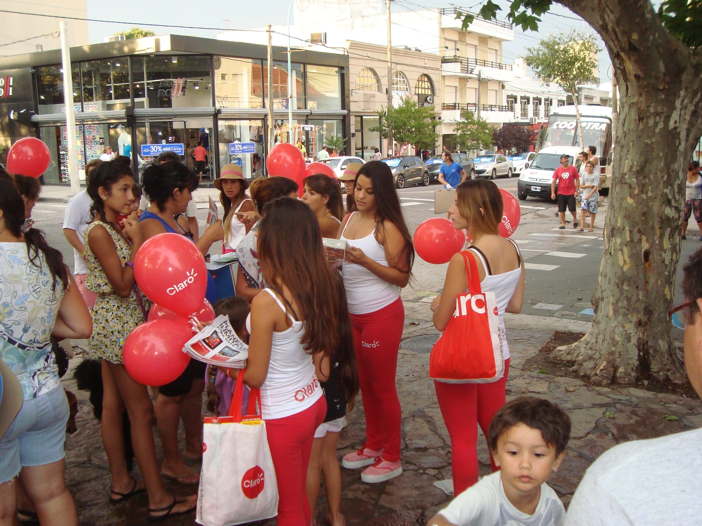 Promotoras de Claro con globos repartiendo folletería en la calle