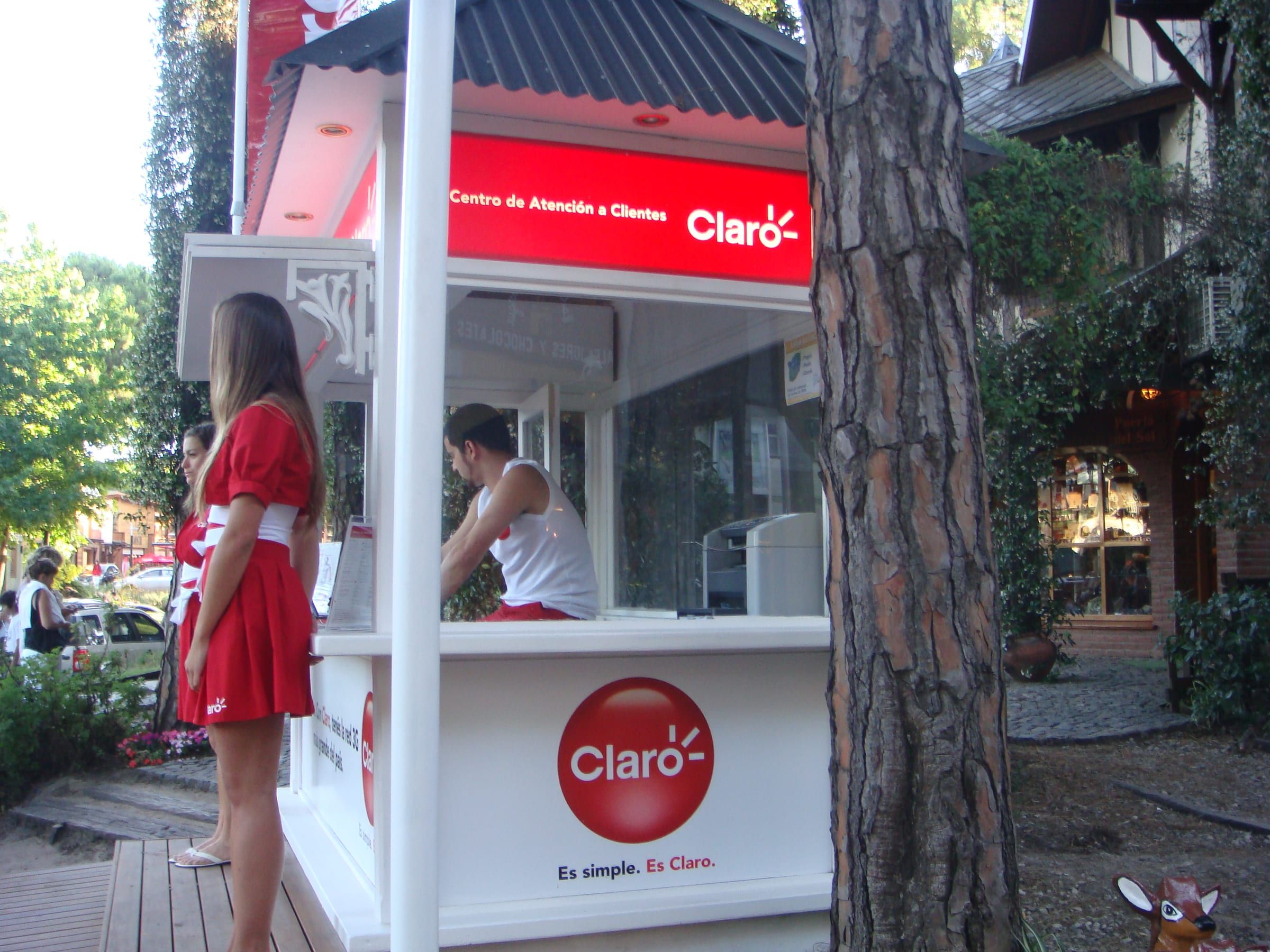 Módulo de atención de Claro en la vereda, con promotora en el mostrador