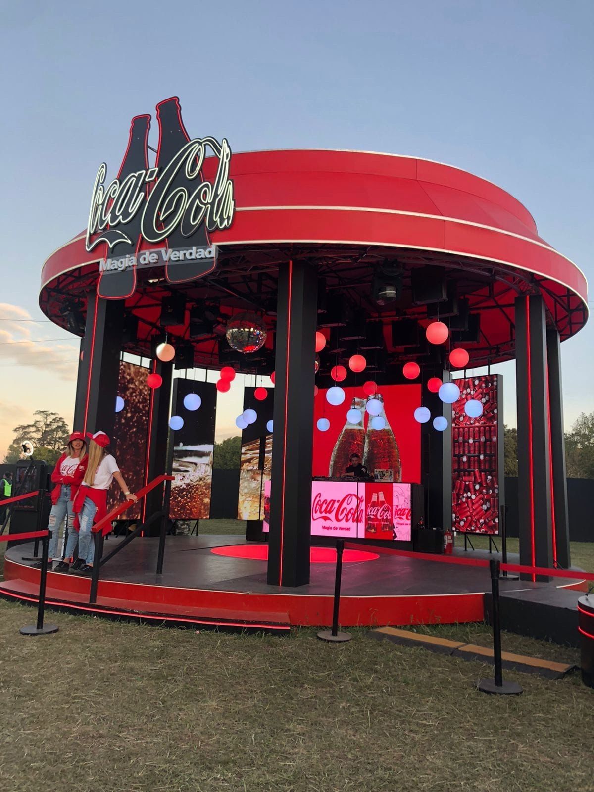 Domo de Coca-Cola al atardecer con esferas de luz y el DJ en la cabina
