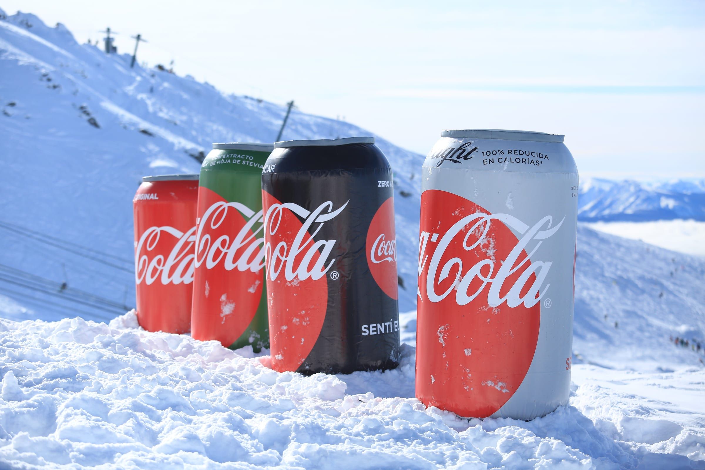 Latas gigantes de Coca-Cola, Sprite y Fanta sobre la nieve