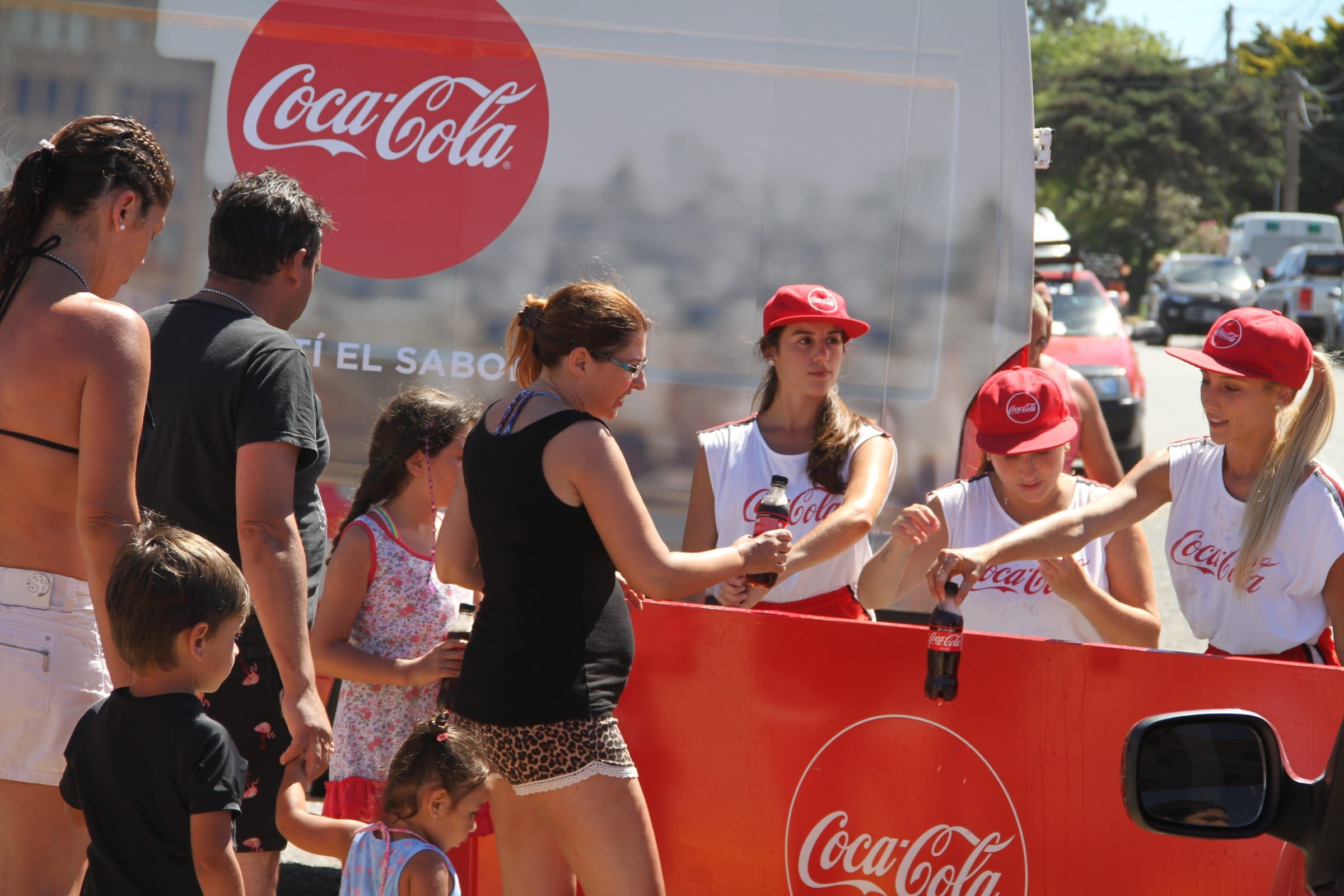 Brigada de Coca-Cola repartiendo bebidas desde el truck