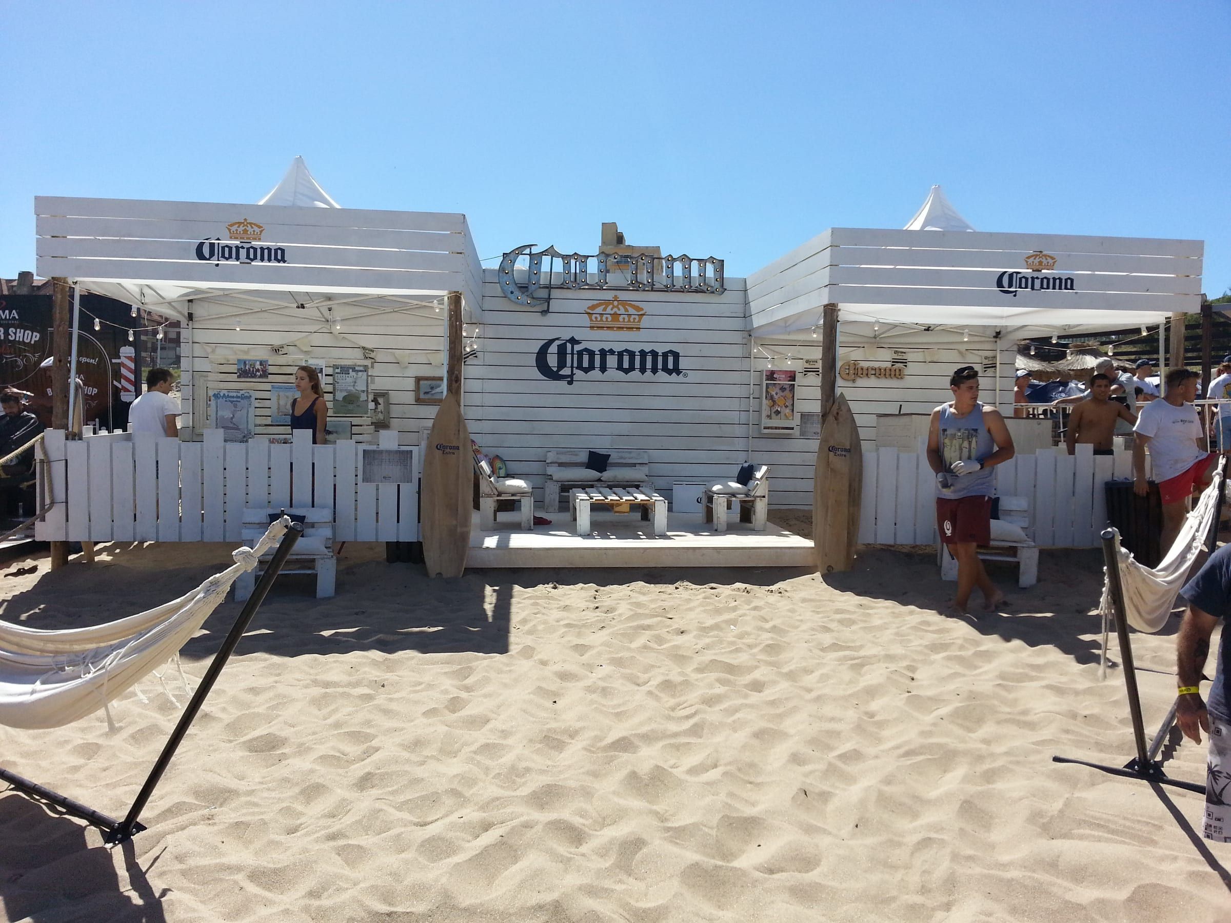 Espacio de Corona en la playa con hamacas y paredes de madera blanca