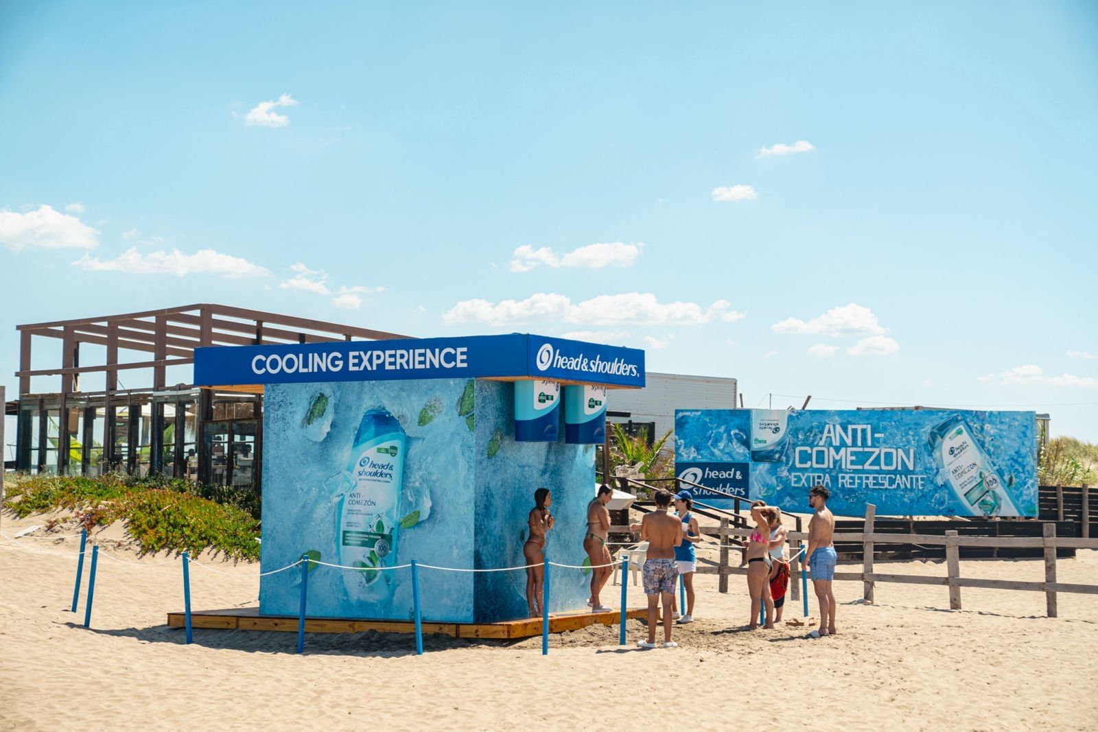 Cubo de Head & Shoulders con duchas y cartel Anti-comezón sobre la arena
