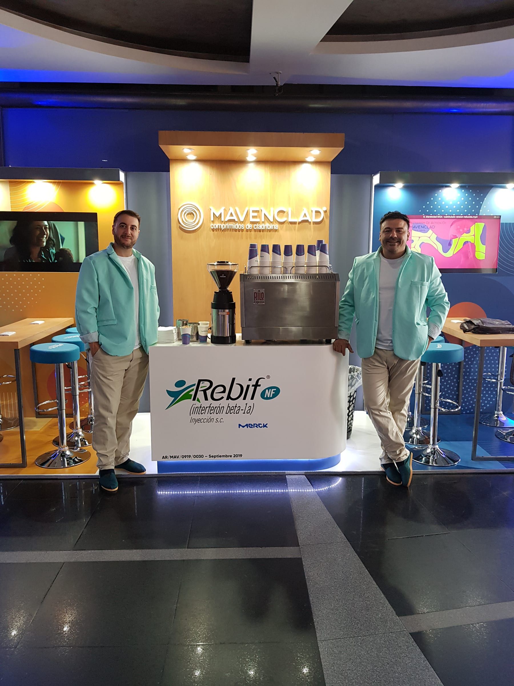 Baristas del stand de Mavenclad frente a la máquina de café