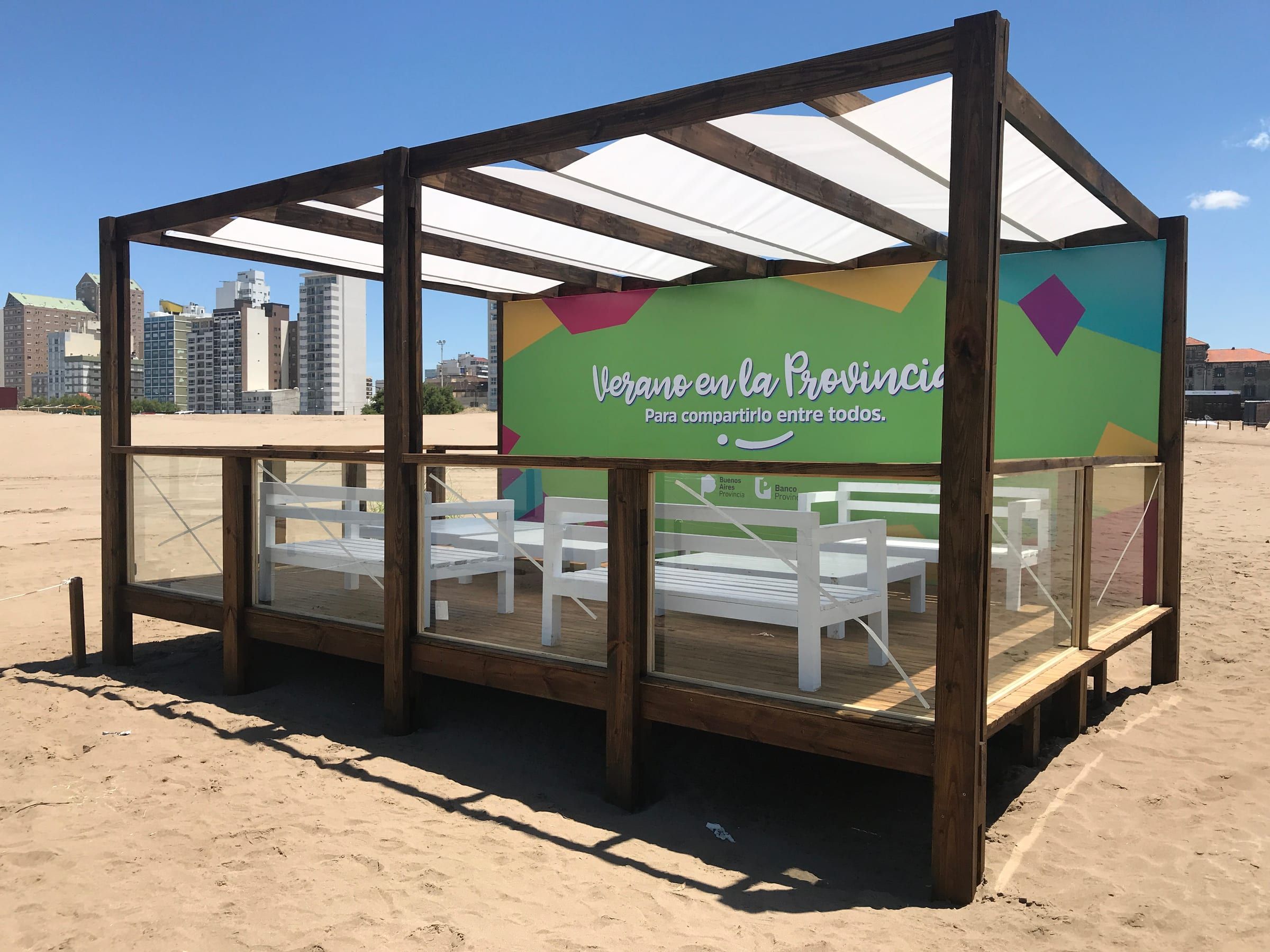 Deck de Verano en la Provincia con sillones blancos y gráfica de colores, sobre la playa de Necochea