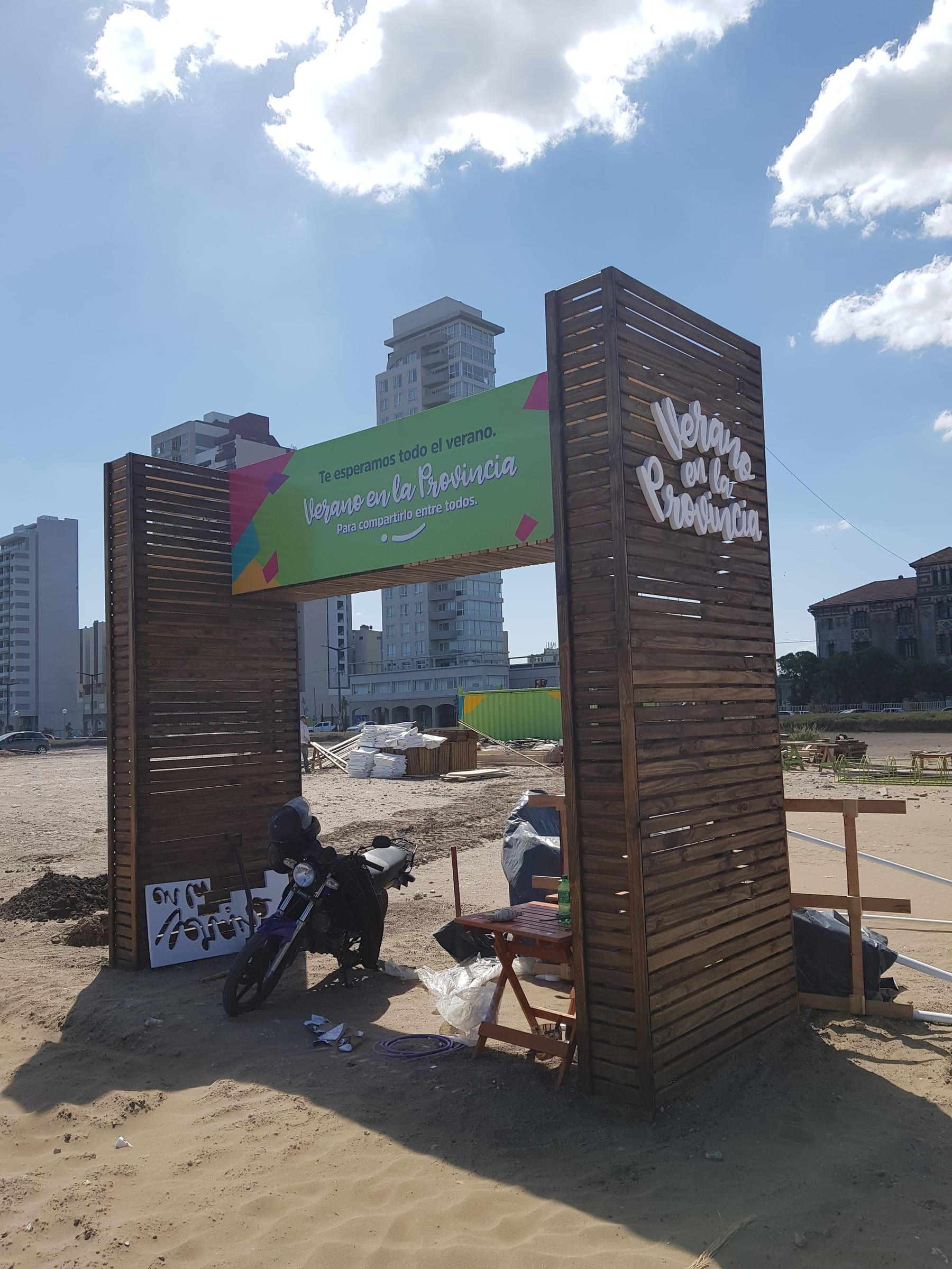 Cartel de Verano en la Provincia en la playa, con los edificios de Necochea detrás