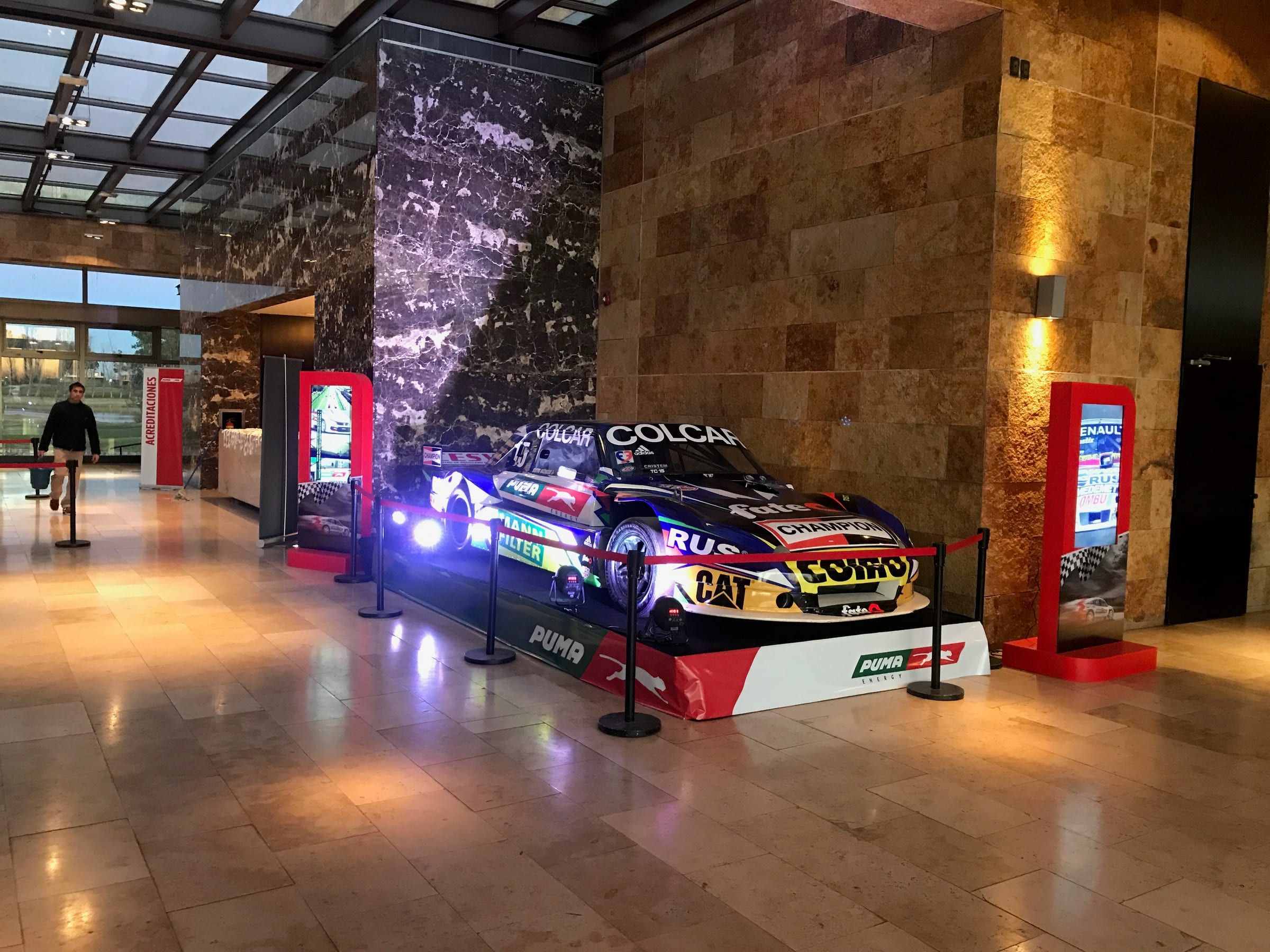 Auto de carrera de Puma Energy iluminado en el hall del evento