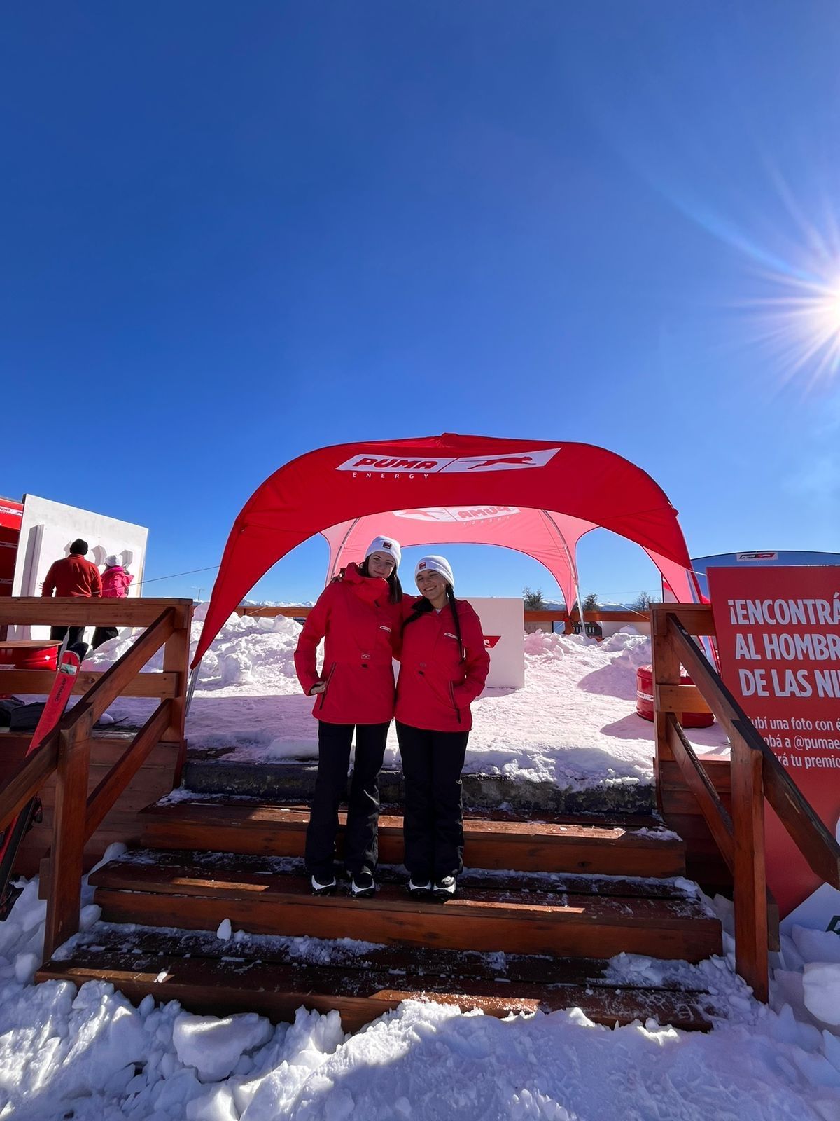 Promotoras de Puma Energy en la escalera del espacio de la marca, sobre la nieve