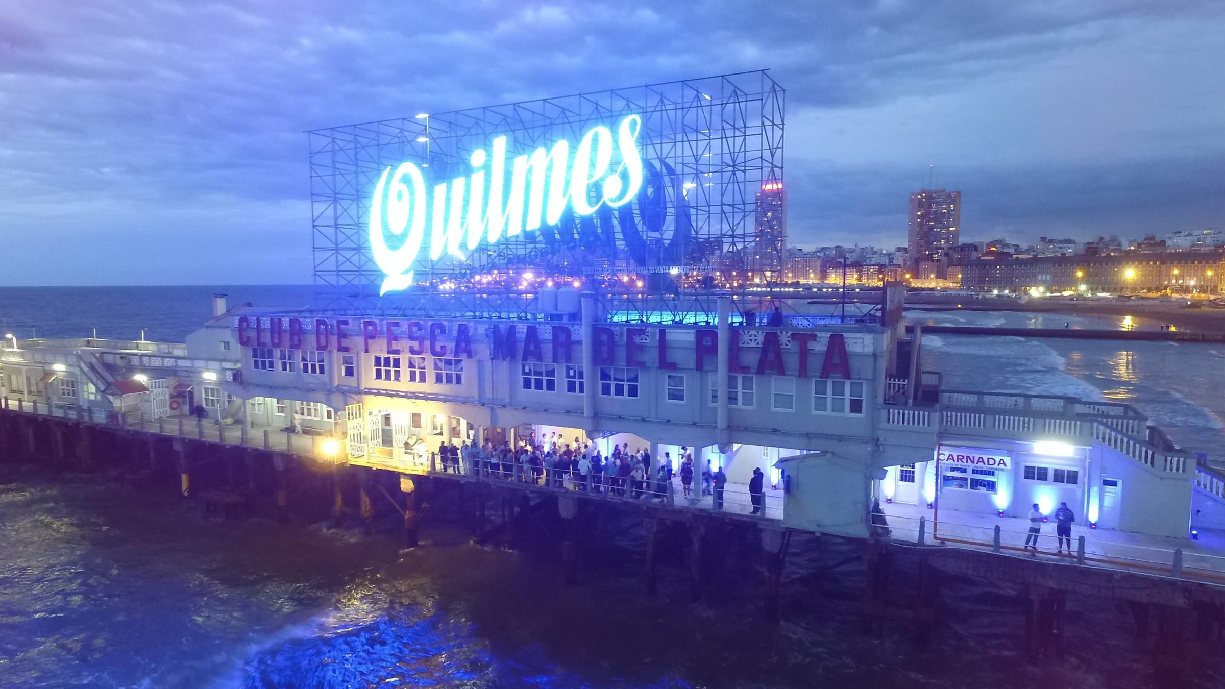Cartel luminoso de Quilmes sobre el Club de Pesca de Mar del Plata, al anochecer