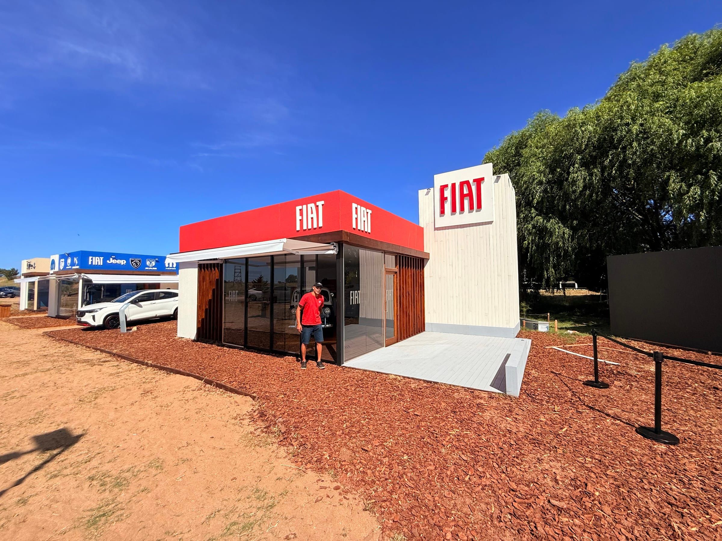Stand rojo de Fiat sobre la pista de tierra del predio
